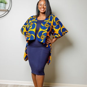 May include: A woman wearing a blue and yellow patterned kimono with a navy blue dress and black heeled sandals. The kimono has a floral design with gold accents.