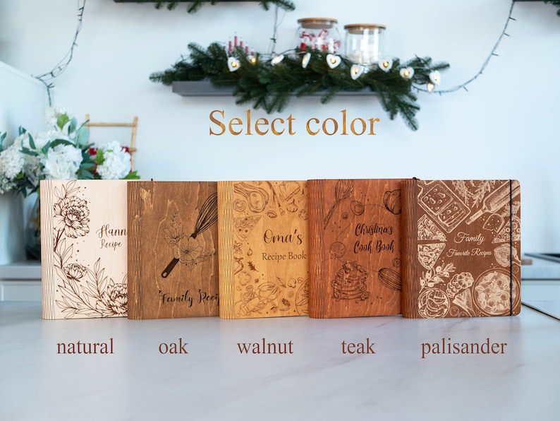 May include: Five wooden recipe books in different wood finishes: natural, oak, walnut, teak, and palisander. Each book has a unique design and text, including "Hann Recipe", "Family Recipe", "Oma's Recipe Book", "Christmas Cook Book", and "Family Favorite Recipes".