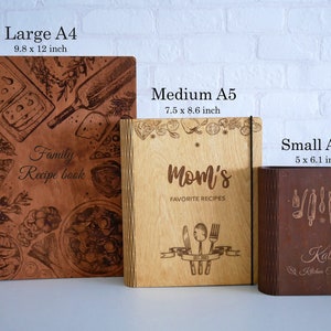 May include: Three wooden recipe books in different sizes. The largest book is brown with a design of food and kitchen items. The middle book is light brown with the text "Mom's Favorite Recipes". The smallest book is dark brown with the text "Kathy's Kitchen Cookbook".