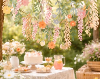May include: A festive outdoor scene with a table set for a party. A garland of paper flowers and leaves hangs overhead. The table is set with a cake, pastries, and a pitcher of pink lemonade. Daisies and other flowers surround the table.