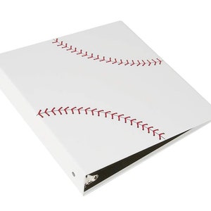 May include: White binder with red stitching resembling a baseball. The binder has a black ring mechanism.