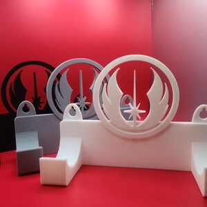 Puede incluir: Tres soportes de pared para sables de luz, cada uno con un color diferente y un s&iacute;mbolo de la Alianza Rebelde de Star Wars. Los soportes son de pl&aacute;stico blanco y tienen un gancho para colgar un sable de luz.