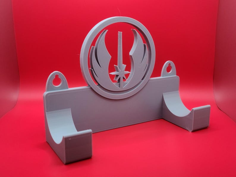 Puede incluir: Un soporte de pared de pl&aacute;stico gris con un recorte circular que presenta el s&iacute;mbolo de la Alianza Rebelde de Star Wars. El soporte tiene dos ganchos para colgar art&iacute;culos.