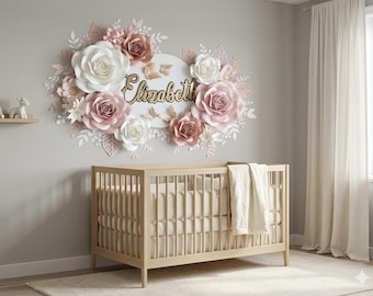 May include: A wooden crib with a white blanket sits below a wall display featuring large paper flowers in shades of white, blush pink, and dusty rose, surrounding a circular sign with the name Elizabeth in gold script and gold butterflies.