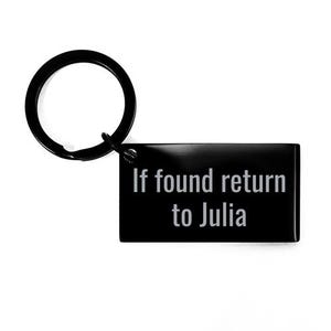 May include: Black rectangular keychain with a black key ring. The text "If found return to Julia" is engraved in white. The keychain is a personalized item.