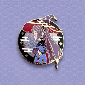 May include: A gold-toned enamel pin featuring a purple-haired anime character wearing a red and gold hat with a pointed tip. The character is standing in front of a black and gold circle with a wave pattern and gold stars.