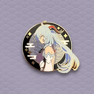 May include: A gold-colored enamel pin featuring a character with long blue and white hair, wearing a white and purple outfit. The character is set against a black background with gold accents and a wave pattern.