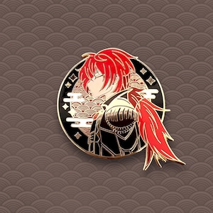 May include: A gold-toned enamel pin featuring a stylized character with red hair and a black and red outfit. The character is set against a black background with white clouds and gold accents.
