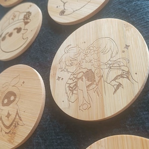 Peut inclure: Ensemble de dessous de verre ronds en bambou, gravés de personnages de style anime. Les dessous de verre présentent des dessins au trait détaillés de diverses figures et étoiles. Le grain naturel du bois offre un fond neutre et chaleureux.