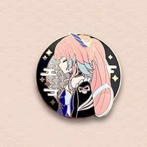 May include: A round enamel pin featuring a side profile of a character with pink hair and blue accents. The pin has a black border with gold stars and a gold outline. The character is set against a background of white and black wave patterns.