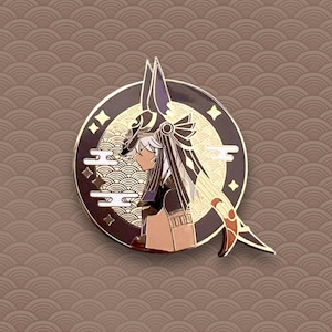 May include: A gold-toned enamel pin featuring a character with black hair and a black and gold headdress. The character is wearing a black and gold outfit and is standing in front of a gold and white background with clouds and stars.