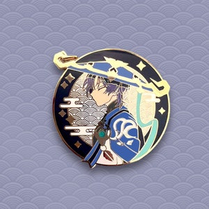 May include: A round enamel pin featuring a blue and gold anime character with purple hair wearing a blue hat with gold accents. The character is set against a black background with gold and white stylized clouds and waves.