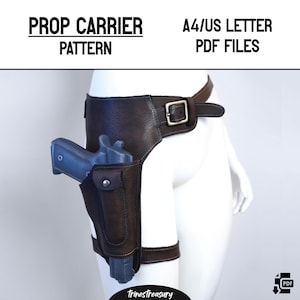 Può includere: Un porta oggetti in pelle marrone con fibbia e fondina che contiene una pistola di scena blu. Il testo "PROP CARRIER PATTERN" e "A4/US LETTER PDF FILES" sono in alto. Il nome del negozio Etsy "TrinesTreasury" è in basso.