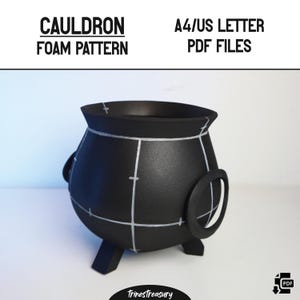 以下が含まれることがあります： 白いグリッド線、ハンドル、脚が付いた黒い大釜のフォームパターン。「CAULDRON FOAM PATTERN」と「A4/US LETTER PDF FILES」の文字が大釜の上に表示されています。 Etsyショップ名「TrinesTreasury」が一番下にあります。