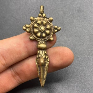 Op de afbeelding: Een gouden metalen hanger met een stervormig ontwerp en een puntige punt. De hanger heeft een rond midden met een bloemmotief.