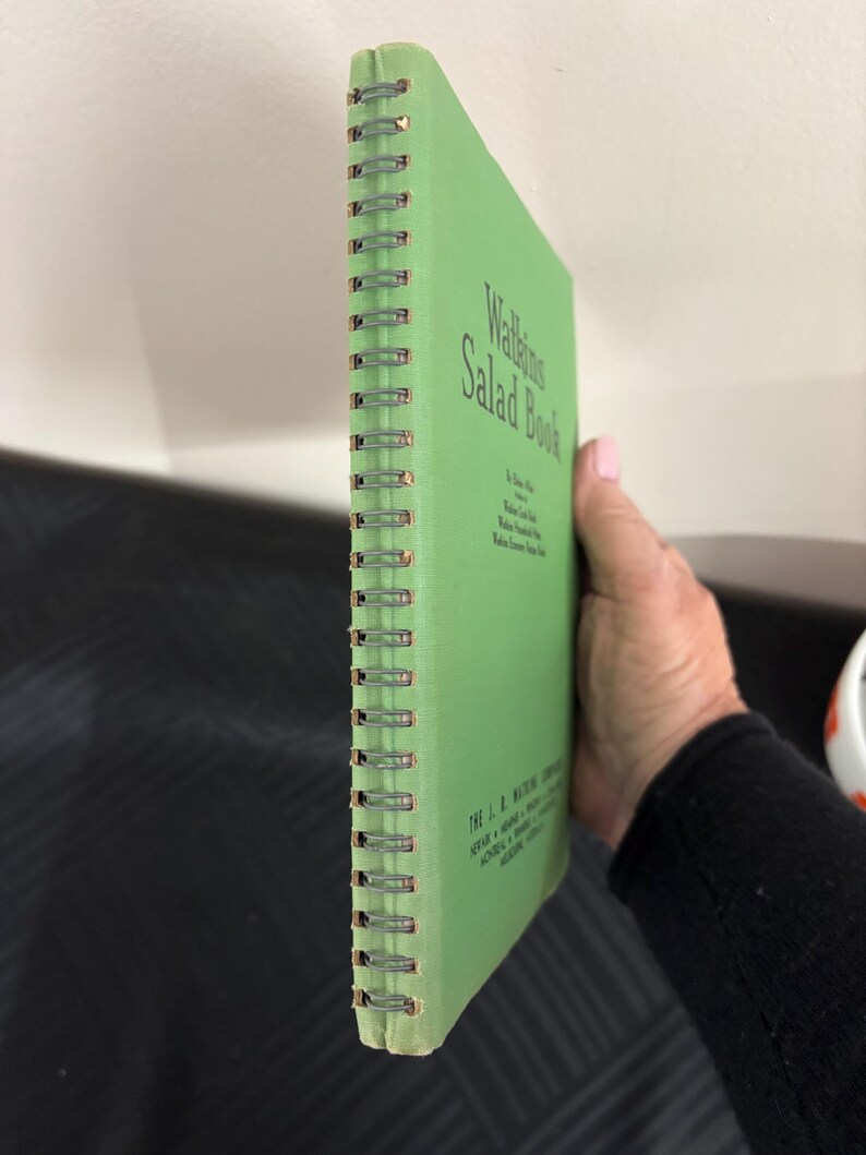 May include: A green spiral bound book titled "Walleigh's Salad Book". The book has a white spine with the text "The L. B. Walleigh Company, Veour - Home - Products - Prices - Dealers - Distributors - Wholesale - Retail - Eastern Shore, Md."