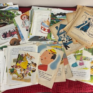 May include: A collection of vintage children's book pages, featuring colorful illustrations and text. The pages depict various scenes, including a fire truck, a doll, and a king. The pages are stacked on a wooden surface.