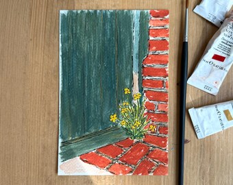May include: Watercolor painting of a green door and red brick wall with yellow flowers. The artwork is on a white paper, with a paintbrush and paint tubes on a wooden surface.