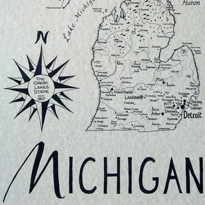 May include: A black and white map of Michigan with the Great Lakes State logo and the text "Si quæris peninsulam amoænam circumspice". The map shows the major cities and towns in the state, including Detroit, Grand Rapids, Lansing, and Ann Arbor.