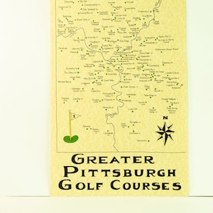 May include: A map of Greater Pittsburgh golf courses. The map is beige with green markers indicating the location of each golf course. The map is surrounded by a black border and the text "GREATER PITTSBURGH GOLF COURSES" is printed in black at the bottom.
