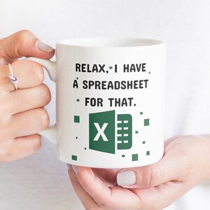 Puede incluir: Taza de cer&aacute;mica blanca con un logotipo de Excel verde y el texto "Relax, I have a spreadsheet for that."