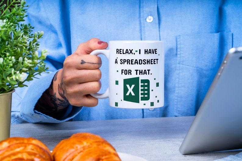 Puede incluir: Taza de caf&eacute; blanca con el texto "Relax, I have a spreadsheet for that." y un logotipo de Excel verde.
