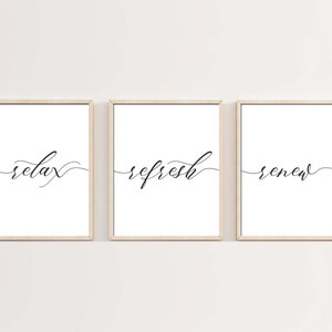 May include: Three framed prints with the words "relax", "refresh", and "renew" written in black cursive script on a white background.