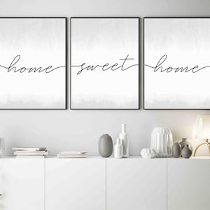 May include: Three black framed prints with a white background and the text "home sweet home" written in black cursive script.