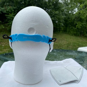 May include: Blue silicone face mask strap with the text "BNM HEALTH" on it. Two black earbud tips are also visible in the image.