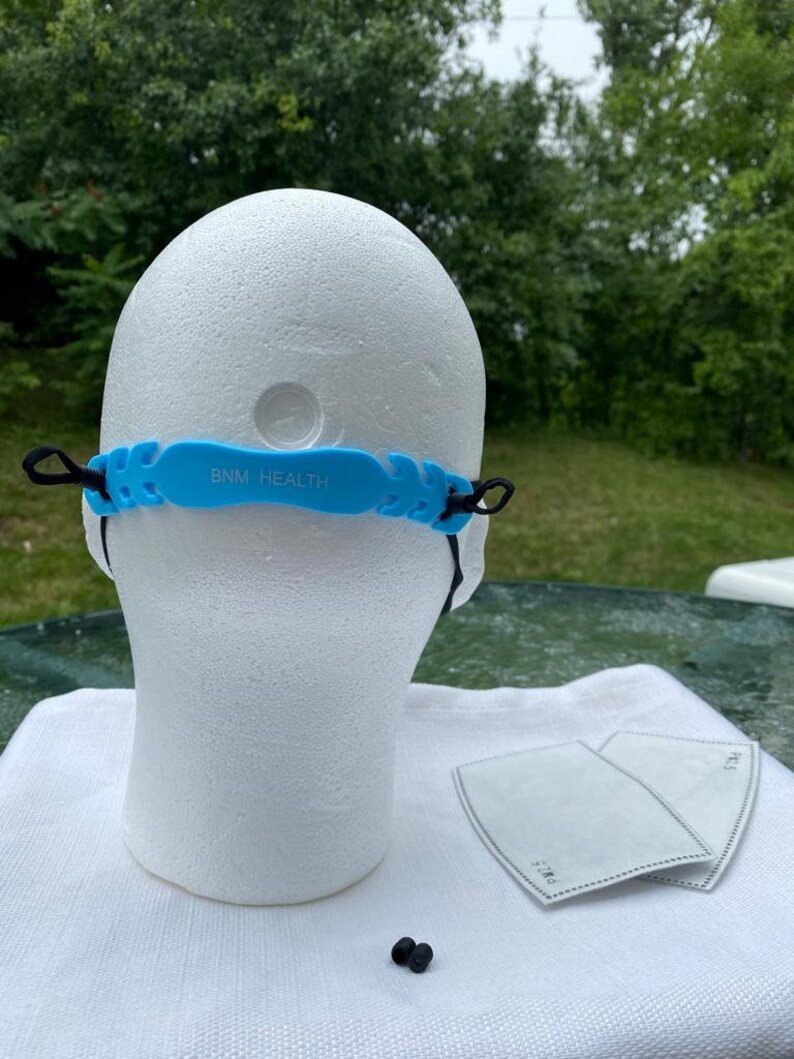 May include: Blue silicone face mask strap with the text "BNM HEALTH" on it. Two black earbud tips are also visible in the image.
