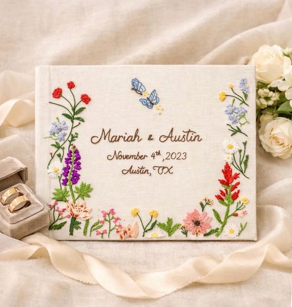 A fully hand-embroidered wedding guest book/photo album — actual needlework art, not a printed cover — makes it a genuine heirloom rather than a shelf-dusty keepsake.