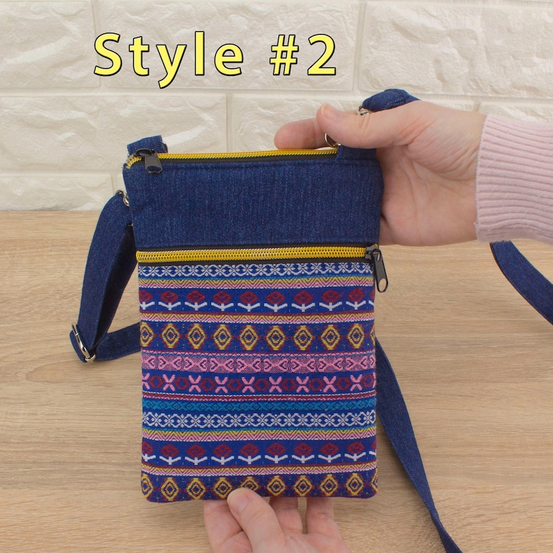 Handmade crossbody bag labeled 'Style #2', featuring a dark blue denim top section, yellow (golden color) zippers, and a bottom pocket made from tapestry textile (geometric pattern).