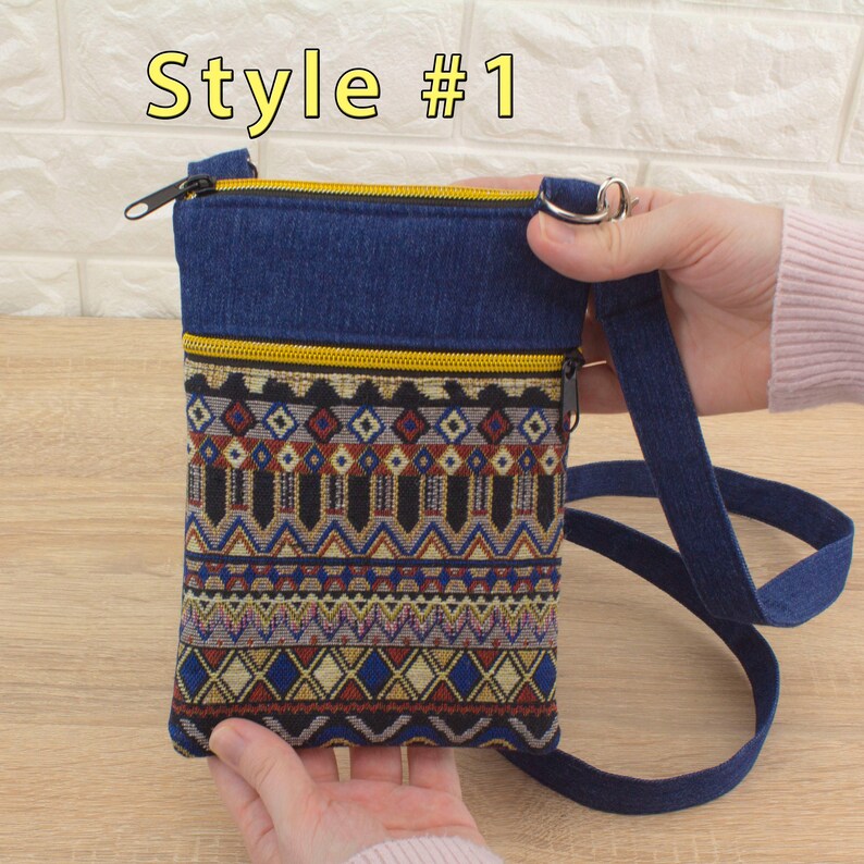 Handmade crossbody bag labeled 'Style #1', featuring a dark blue denim top section, yellow (golden color) zippers, and a bottom pocket made from tapestry textile (geometric pattern).