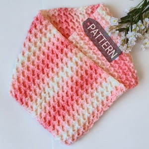 May include: A pink and white ombre crochet scarf with a tag that says "PATTERN".