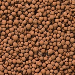 May include: Close-up of a large quantity of small, round, terracotta-coloured clay pebbles. The pebbles are used for drainage and aeration in gardening and plant care.