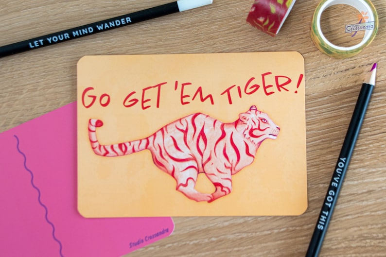 Kaart met de tekst Go Get 'Em Tiger! op een houten oppervlakte.