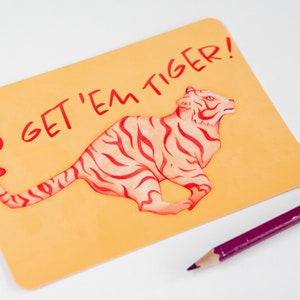 Kaart met de tekst Go Get 'Em Tiger! op een wit oppervlakte.