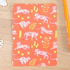 May include: A coral orange background with a repeating pattern of white tigers and yellow foliage. The tigers are in various poses, some are lying down, some are walking, and some are jumping. The foliage is stylized and includes leaves, branches, and flowers.