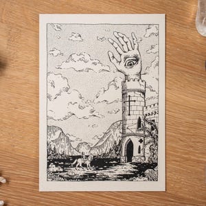 May include: Black and white illustration of a surreal landscape featuring a tower with a hand and eye, a figure on horseback, and mountains. The artwork is on a cream-colored card, with decorative elements on a wooden surface.