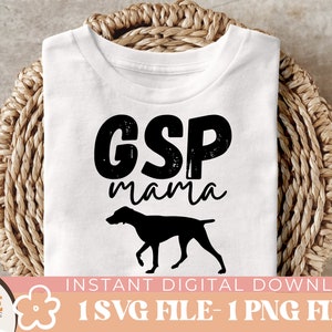 May include: White t-shirt with black text that says "GSP mama" and a black silhouette of a German Shorthaired Pointer dog.