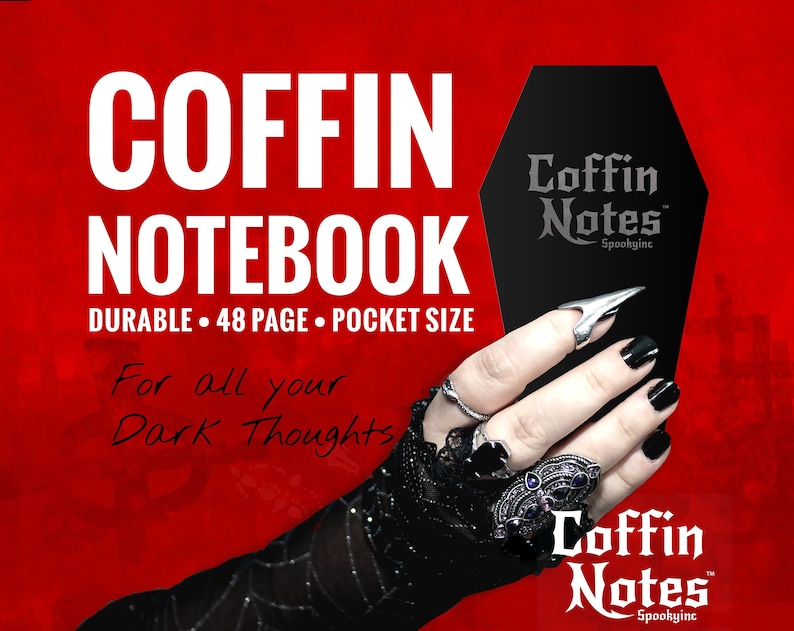 Może przedstawiać: Czarny notes w kształcie trumny z napisem "Coffin Notes" i "Spookyinc" na przodzie. Notes jest trzymany przez rękę w czarnej koronkowej rękawiczce i srebrnych pierścionkach. Tło jest czerwone.