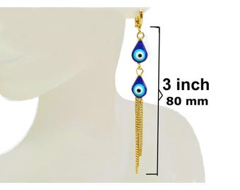 May include: Gold-tone earrings with blue teardrop-shaped charms featuring an eye design. The earrings, measuring 3 inches (7.6 cm) in length, have a chain tassel and a lever-back closure. The eye charms are blue with a white and black center.