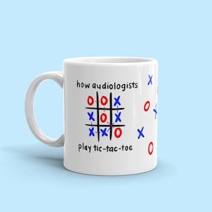 Può includere: Una tazza in ceramica bianca con un gioco di tris in bianco e nero stampato su di essa. Il testo "how audiologists play tic-tac-toe" è stampato sulla tazza. Il gioco di tris ha cerchi rossi e X blu.