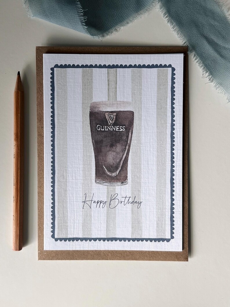 May include: A greeting card featuring a watercolor illustration of a pint of Guinness stout. The card has a striped background and a scalloped border. The words "Happy Birthday" are written below the pint.