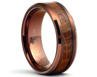 May include: A brown tungsten ring with a wood inlay. The ring is engraved with the word "TUNGSTEN".