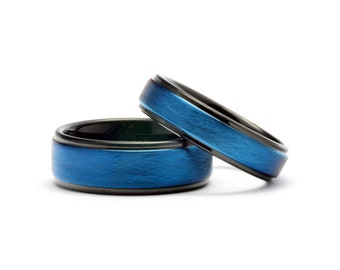 May include: Two blue and black wedding bands. The bands have a brushed finish and a blue inlay.