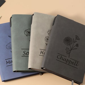 May include: Four gray, blue, and black journals with floral designs and personalized names. The names are "Sophia", "Hannah", and "Chappell".