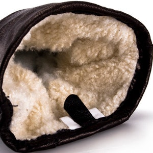 May include: Brown leather mitten with a soft, white fleece lining. The mitten has a black strap.