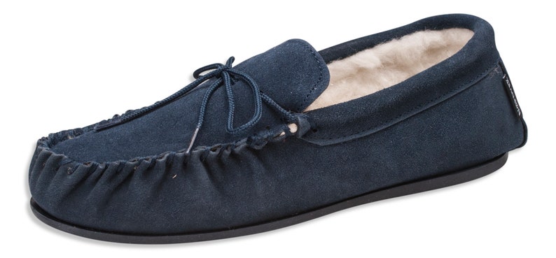 Pu&ograve; includere: Ciabatte mocassino in pelle scamosciata blu navy con fodera in montone e un laccio decorativo.