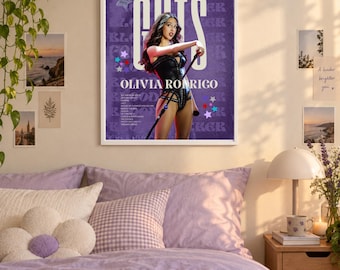 May include: A rectangular poster featuring a purple background with the text GUTS and OLIVIA RODRIGO. The poster displays a person in a black outfit holding a microphone stand, surrounded by small star icons and additional tour text details.